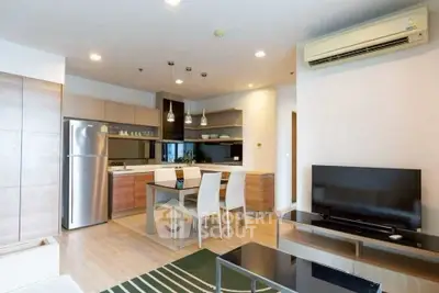 Modern open-plan living room with kitchen, dining area, and sleek appliances.