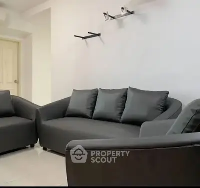 Modern living room with sleek dark sofas and minimalist decor