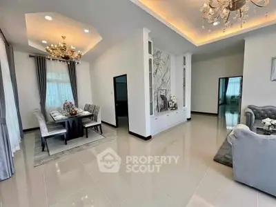 Luxurious open-plan living and dining area with elegant chandeliers and modern decor.