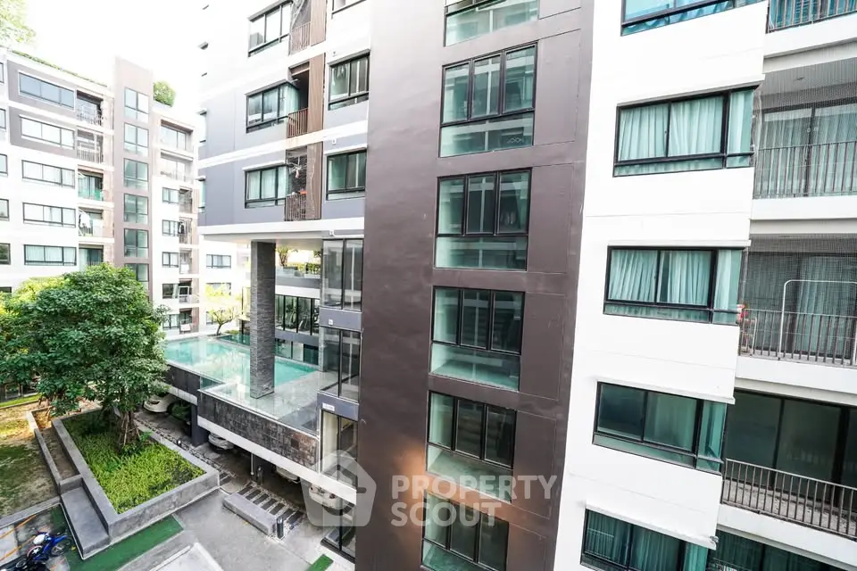 Modern apartment building with pool and garden view, showcasing contemporary architecture and urban living.