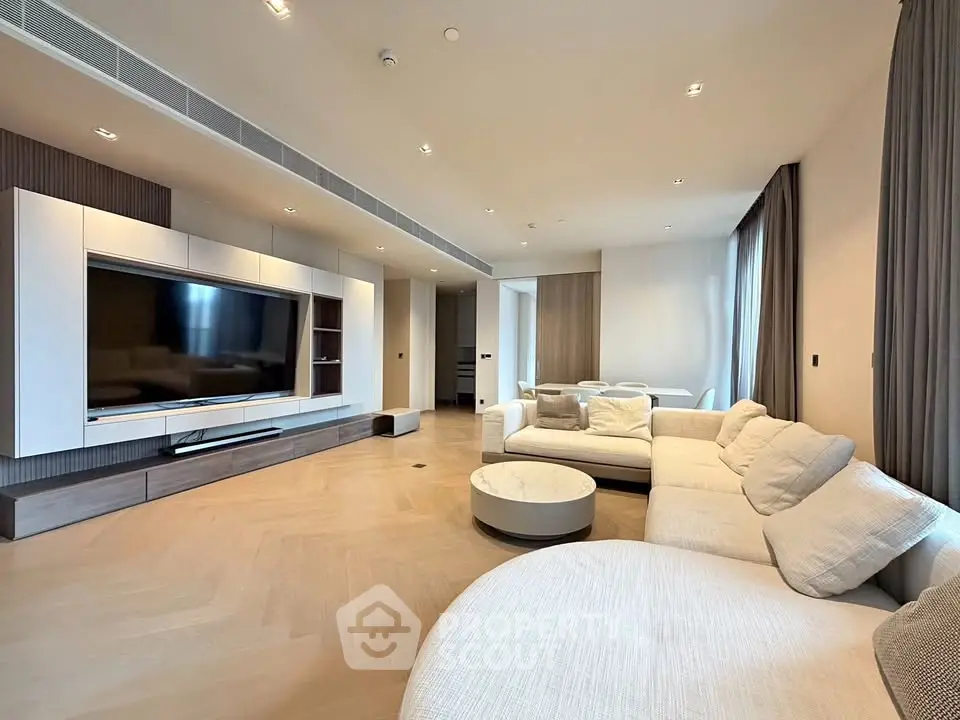 Spacious modern living room with elegant furniture and large TV, perfect for relaxation and entertainment.
