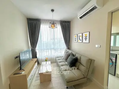 Modern living room with stylish decor, featuring a comfortable sofa, wall art, and a large window with city view.