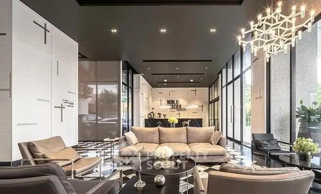 Luxurious modern lobby with elegant seating and stylish lighting in upscale building.