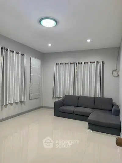 Modern living room with sleek gray sofa and elegant curtains