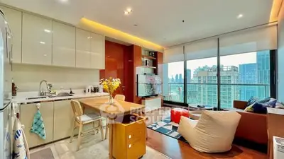 Modern open-plan kitchen and living room with city view and stylish decor.