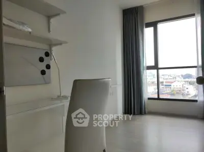 Bright study room with large window and modern desk in high-rise apartment.