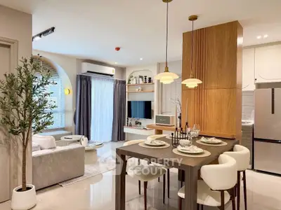 Modern open-plan living room and kitchen with stylish decor and natural light.