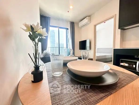 Modern living room with dining area and city view, featuring stylish decor and natural light.
