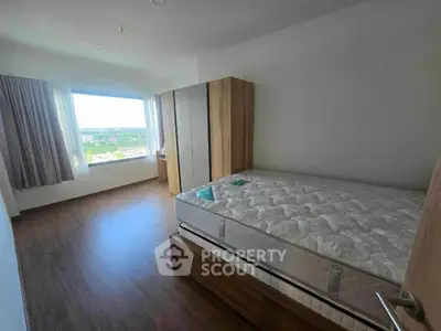 Spacious bedroom with large window offering scenic views and ample natural light.
