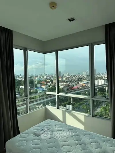 Stunning corner bedroom with panoramic city views and abundant natural light.