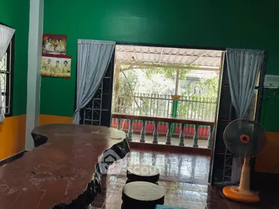 Charming living room with unique wooden table and garden view, perfect for relaxation.