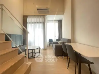 Modern living room with high ceiling and stylish furniture in a bright apartment.