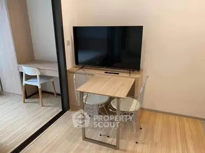Modern compact living room with sleek TV setup and minimalist furniture design.