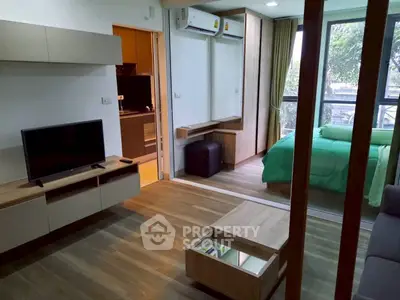 Modern apartment interior with open layout, featuring living room and bedroom with large windows.