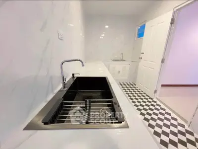 Modern kitchen with sleek black sink and checkered floor tiles