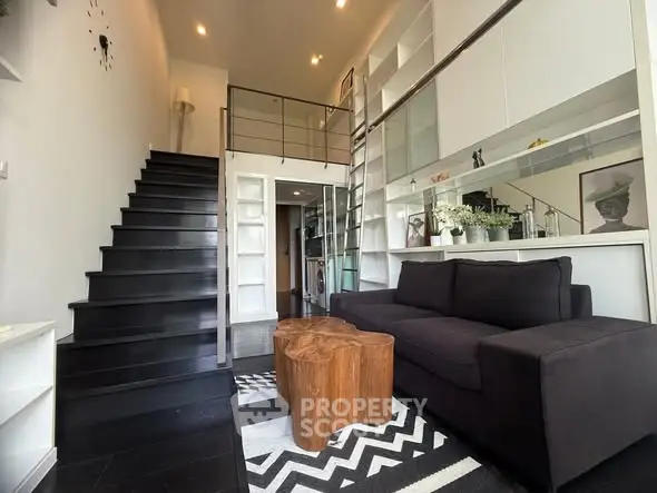 Modern loft-style living room with mezzanine and sleek black staircase