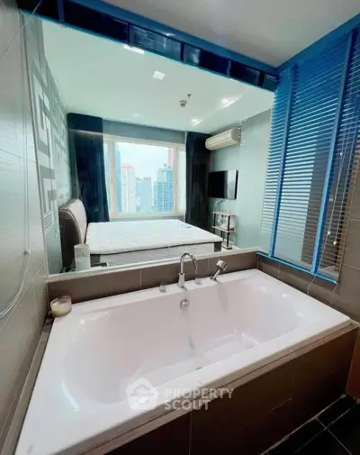 Luxurious bathroom with bathtub and city view from window, modern design and sleek finishes.