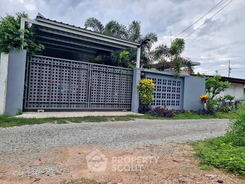 Charming suburban home with modern gate and lush greenery, perfect for tranquil living.