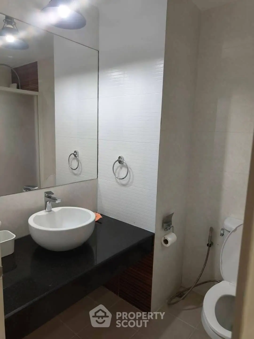 Modern bathroom with sleek sink and toilet in a minimalist design.
