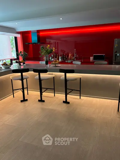Modern kitchen with sleek red backsplash and stylish bar seating