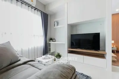 Modern living room with sleek TV unit and cozy sofa in bright apartment