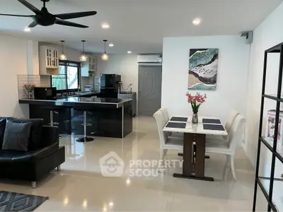 Modern open-plan living room and kitchen with sleek design and stylish decor.