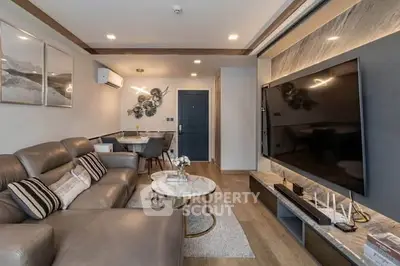 Modern living room with sleek design and large TV, perfect for entertainment.