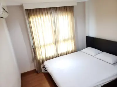 Cozy bedroom with natural light and modern furnishings, perfect for relaxation.