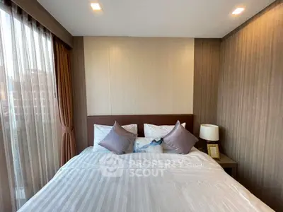 Cozy bedroom with elegant decor and ample natural light in modern apartment.