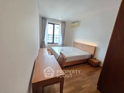 Spacious bedroom with wooden furniture and natural light