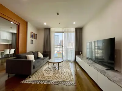Spacious modern living room with large TV and city view, perfect for urban living.