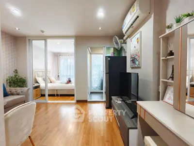 Modern apartment interior with open living room and bedroom, featuring wooden flooring and stylish decor.