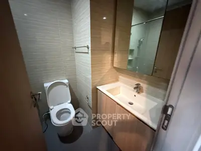 Modern bathroom with sleek fixtures and elegant wood accents.