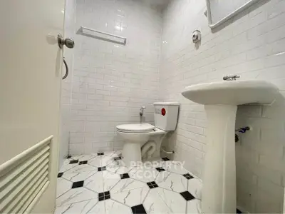 Modern bathroom with white subway tiles and geometric floor design
