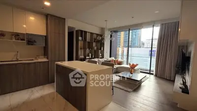 Modern open-plan living room and kitchen with city view, featuring sleek design and natural light.