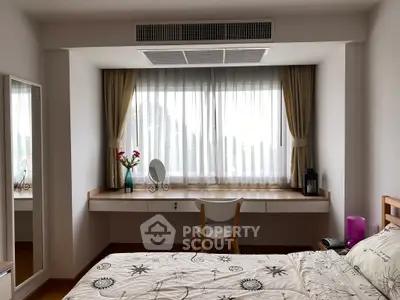 Bright bedroom with large window, elegant curtains, and stylish decor, featuring a cozy bed and a chic vanity area.