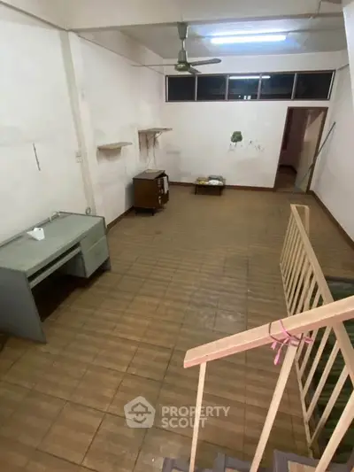 Spacious interior with wooden flooring and staircase, ideal for creative renovation.