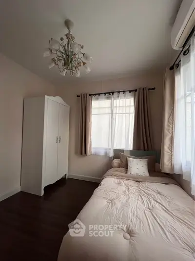Cozy bedroom with elegant chandelier and natural light