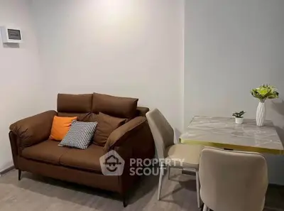 Cozy living room with modern brown sofa and elegant dining table, perfect for small spaces.