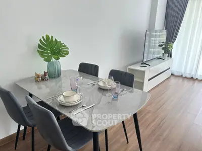 Modern dining area with elegant table setting and sleek TV setup