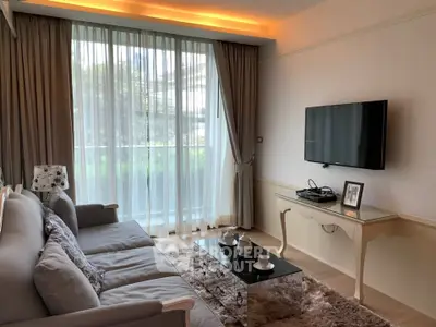 Elegant living room with large window, cozy sofa, and mounted TV, perfect for relaxation and entertainment.
