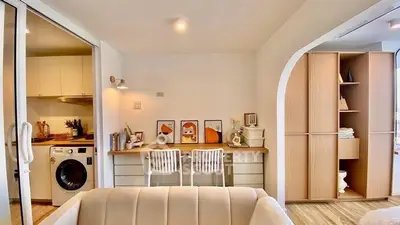 Modern living room with stylish study area and washing machine in cozy apartment