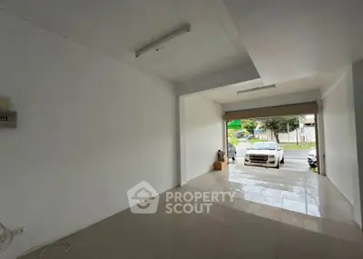 Spacious garage with tiled flooring and open entrance, ideal for parking or storage.