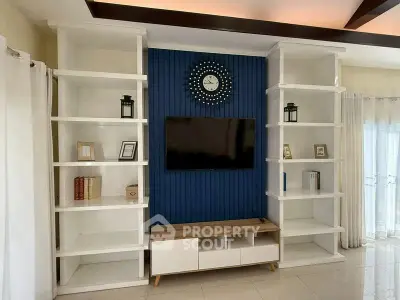 Modern living room with stylish shelving and wall-mounted TV