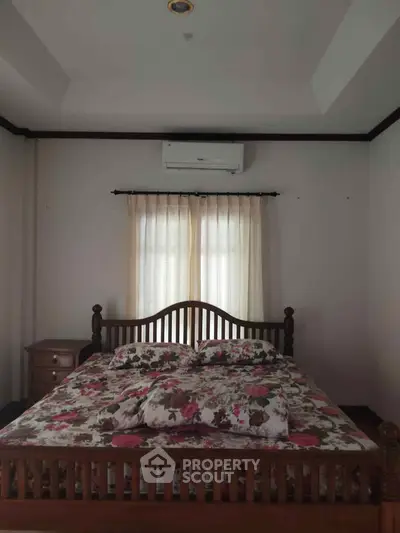 Cozy bedroom with floral bedding and air conditioning unit