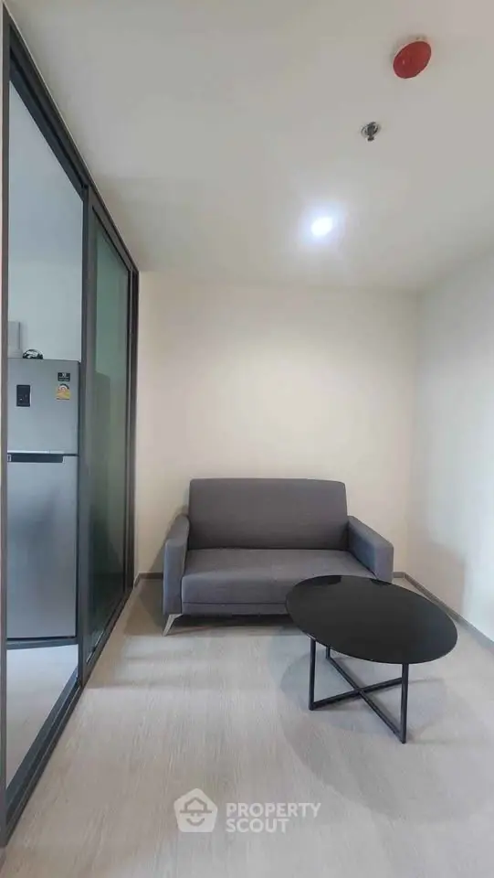 Modern living room with sleek gray sofa and stylish black coffee table in a cozy apartment.