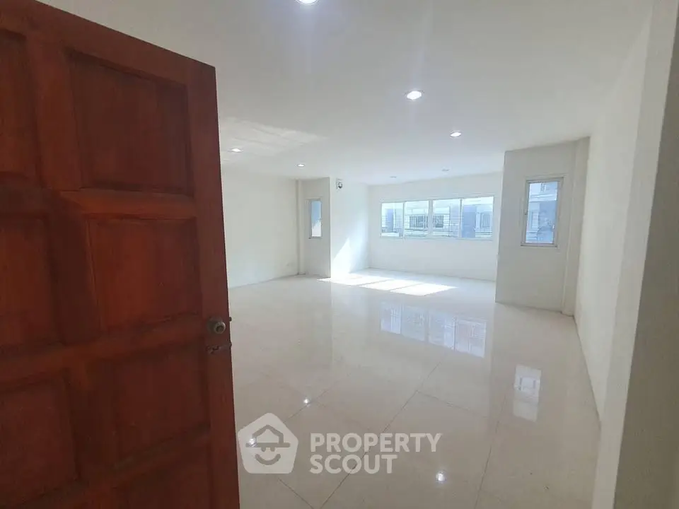 Spacious empty room with large windows and glossy tiled floor