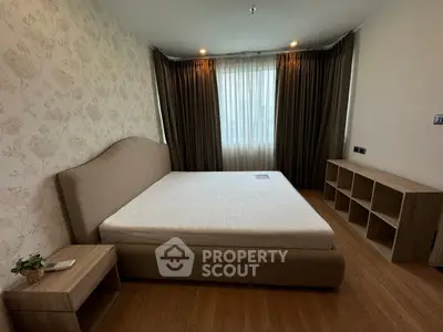 Spacious bedroom with elegant decor and natural light, featuring a comfortable bed and stylish wooden furniture.