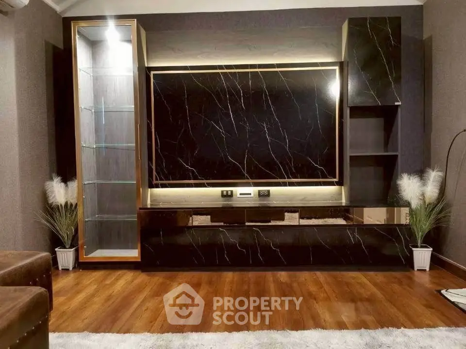 Luxurious living room with elegant marble TV wall and wooden flooring