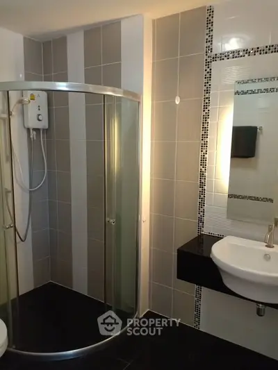 Modern bathroom with sleek shower enclosure and stylish sink area.
